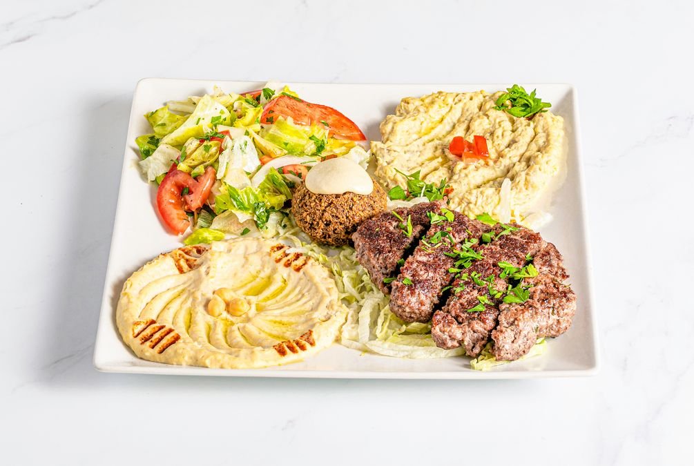 Hummus (crema de garbanzos con salsa de sésamo), Mutabal (crema de berenjena asada con salsa de sésamo), Falafel (croqueta de garbanzos y cilantro verde), Kafta (hamburguesa a la libanesa con cebolla, perejil y especias a la barbacoa) y Ensalada. (sin gluten/halal)